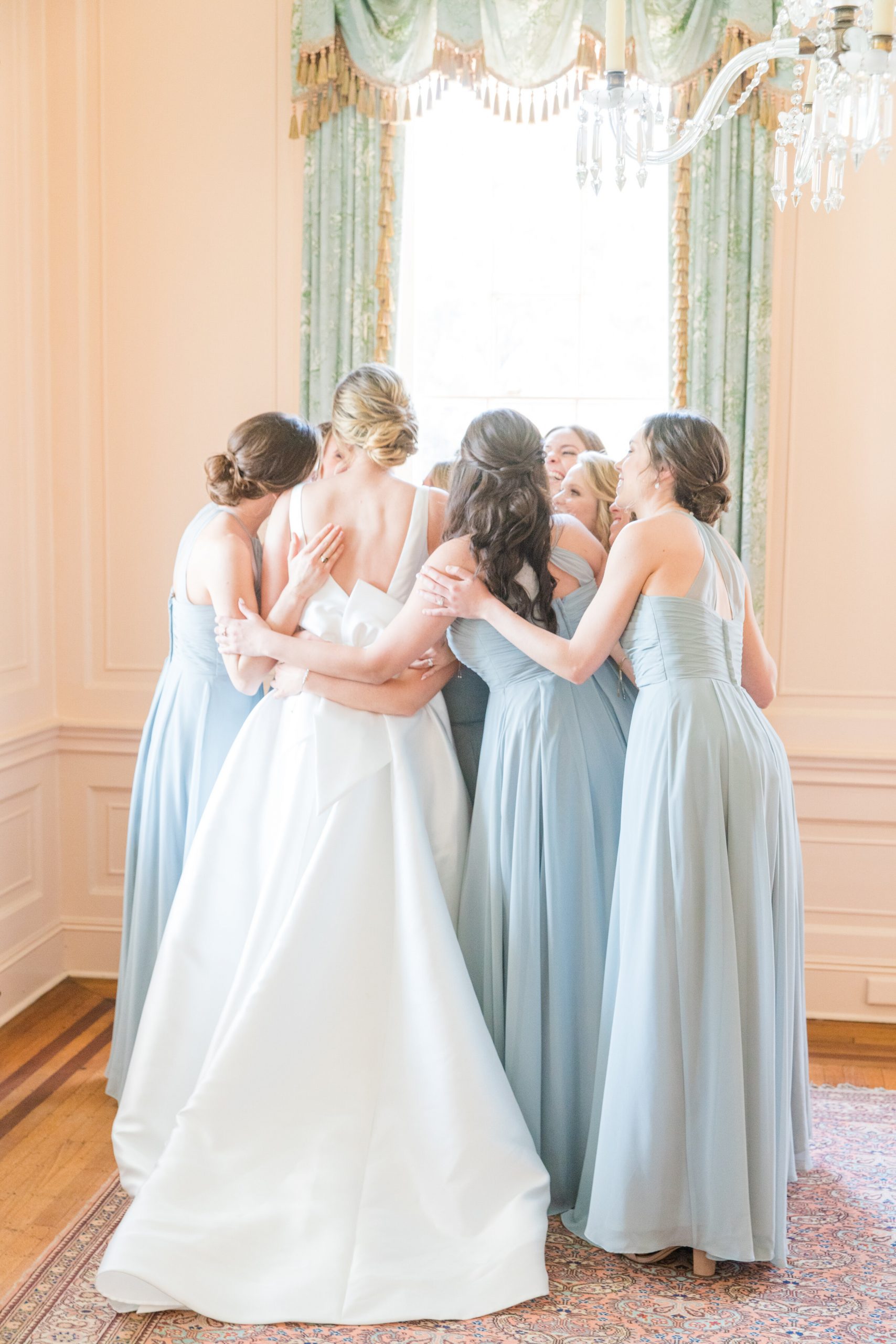 bride and bridesmaids hug at lowndes grove charleston wedding venue